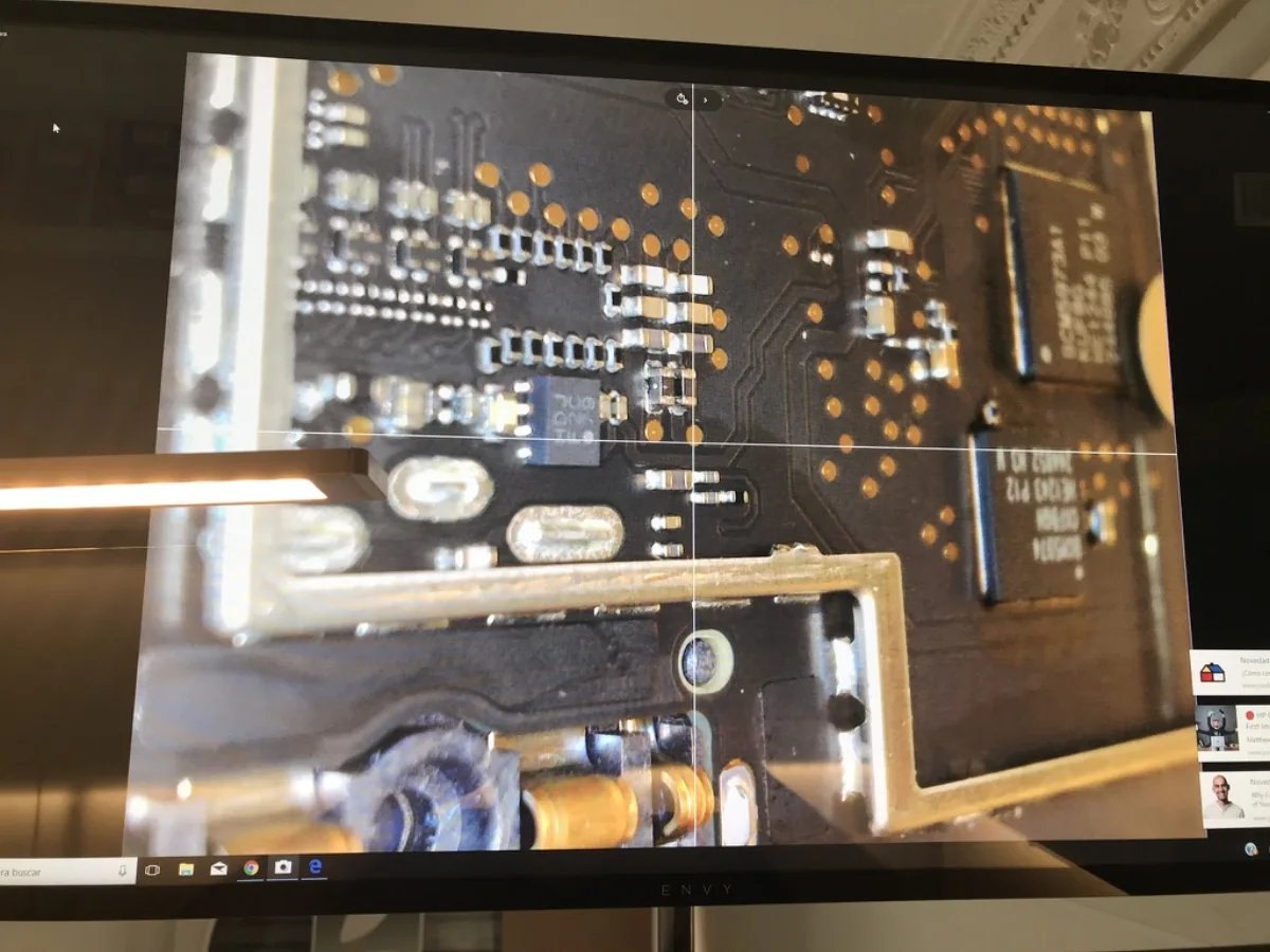 Técnico trabajando con microscopio en placa PCB